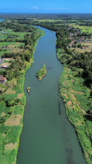 River Flowing Through Green Fields